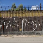 The city of Nogales is divided in two by the Mexico-US border. This photograph shows the Mexican side, commemorating those who have died trying to cross into the United States.  Jonathan McIntosh, “Wall of Crosses in Nogales,” 2009. CC BY 2.0, via Flickr.